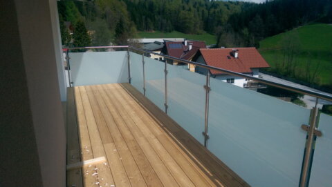 Detailaufnahme Handlauf und Glasklemme aus Edelstahl an Glasgeländer